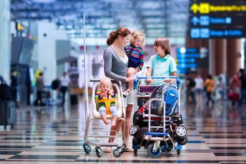 Maintaining your baby’s healthy sleep habits while on vacation - mom with children at an airport waiting for vacation to start